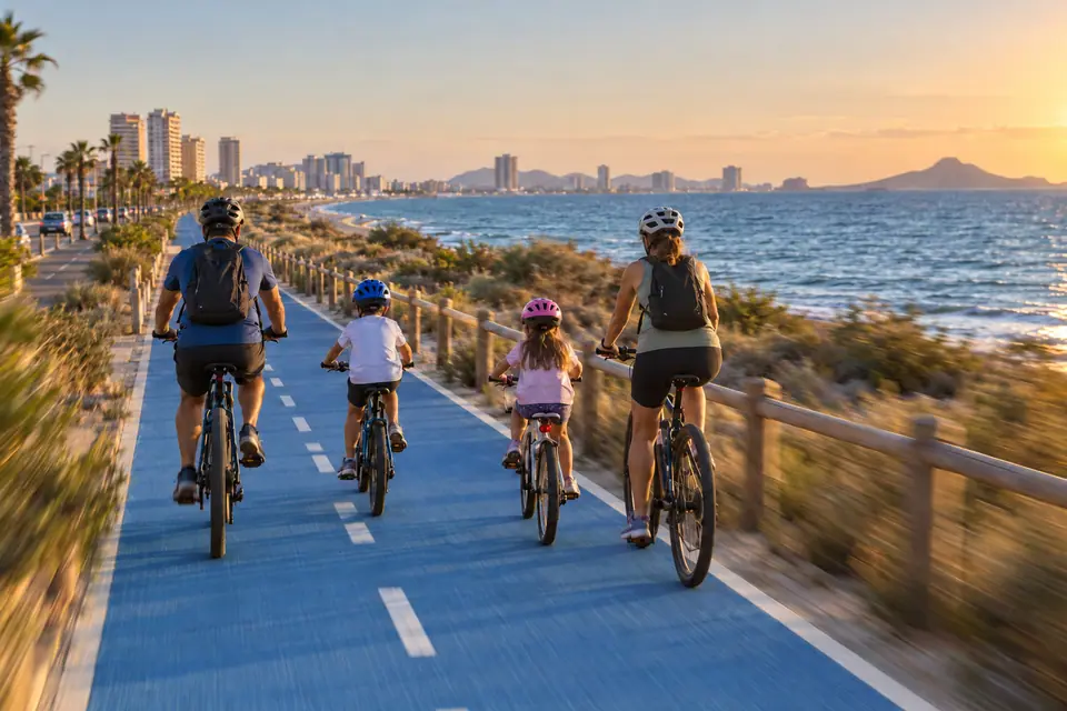 Familia en bicicleta por el carril bici junto al mar